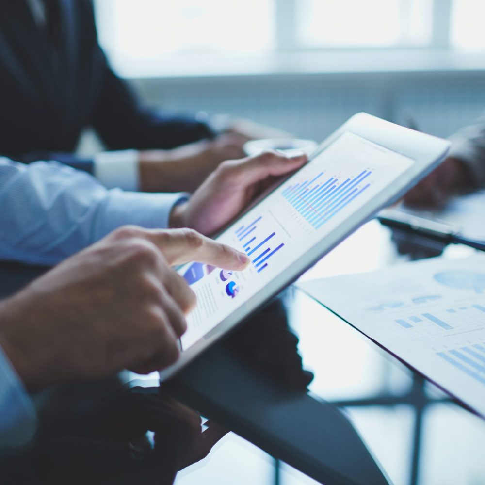 Analyzing electronic document Image of businessperson pointing at document in touchpad at meeting